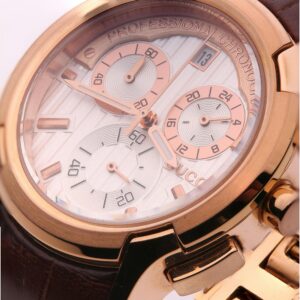 Detailed close-up of a luxurious gold chronograph watch with brown leather strap.